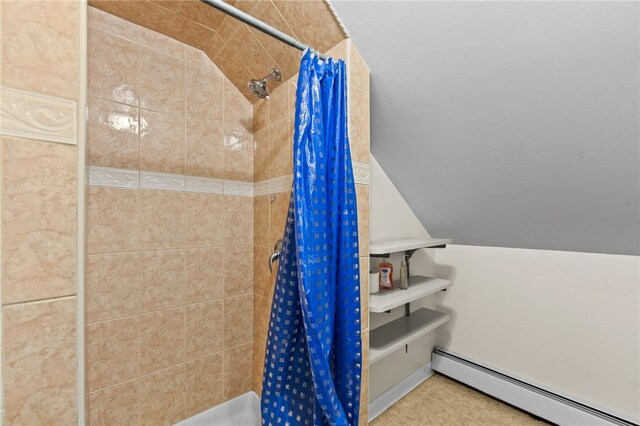 bathroom with a tile shower, lofted ceiling, tile patterned floors, and baseboard heating