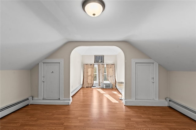 bonus room featuring a baseboard radiator, lofted ceiling, light wood finished floors, and baseboard heating