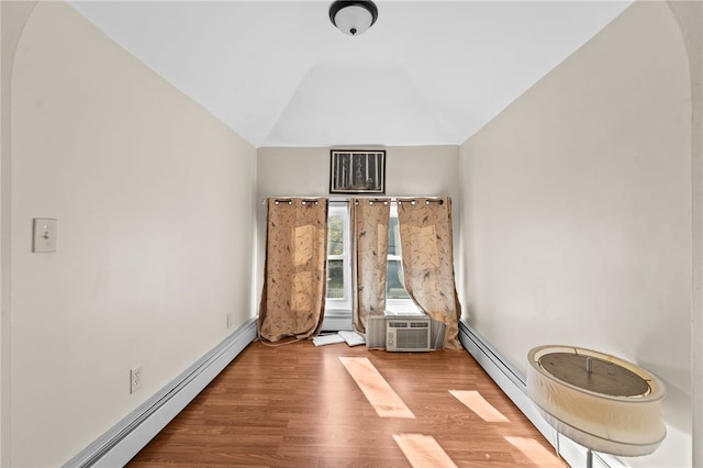 unfurnished room with a baseboard radiator, lofted ceiling, and wood finished floors