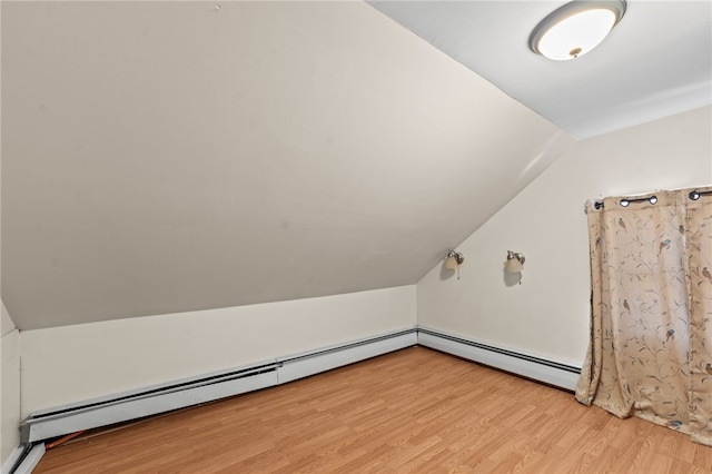 bonus room featuring lofted ceiling, light wood-style flooring, and baseboard heating