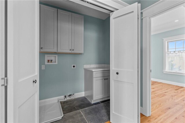 laundry room featuring baseboards, washer hookup, cabinet space, electric dryer hookup, and ornamental molding