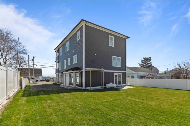 rear view of property featuring a fenced backyard and a yard