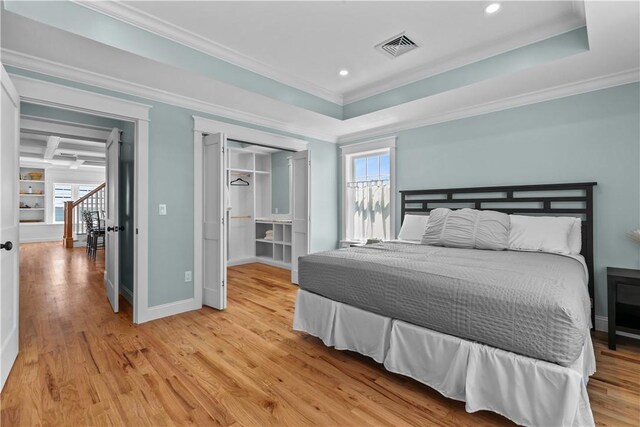 bedroom with crown molding, light wood-type flooring, baseboards, visible vents, and recessed lighting