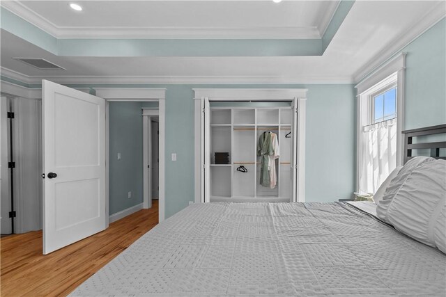 bedroom featuring visible vents, recessed lighting, wood finished floors, a closet, and ornamental molding