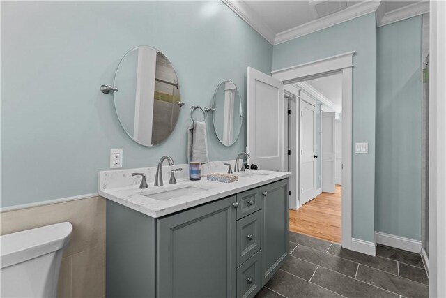 full bath featuring tile patterned floors, a sink, ornamental molding, and toilet