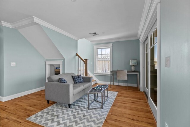 living room featuring baseboards, crown molding, wood finished floors, and visible vents