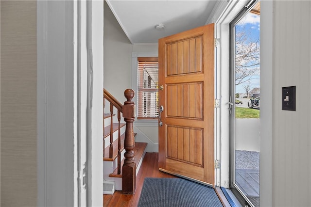 entrance foyer with ornamental molding, plenty of natural light, wood finished floors, and stairway