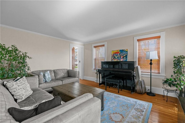 living area featuring baseboards, crown molding, and wood finished floors