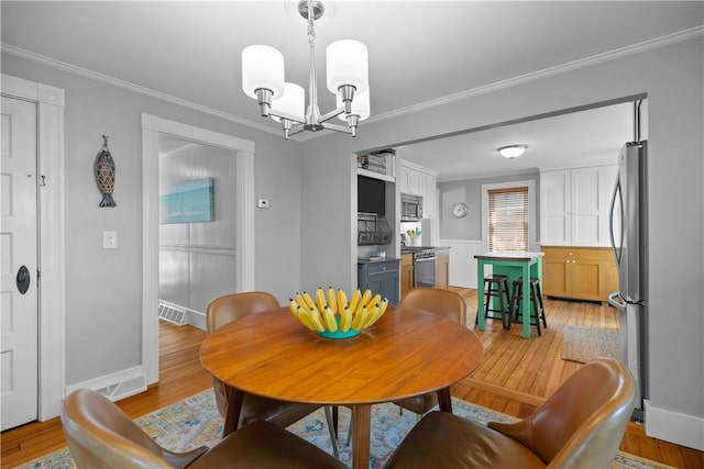 dining area featuring light wood-type flooring, visible vents, a notable chandelier, and ornamental molding