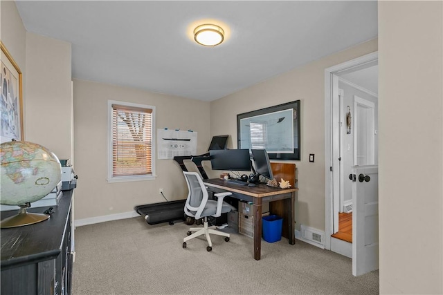 carpeted office space with plenty of natural light, baseboards, and visible vents