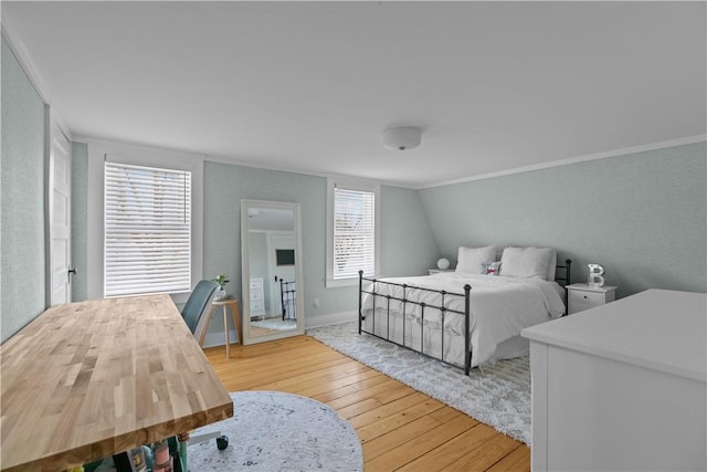 bedroom with light wood-style floors and ornamental molding