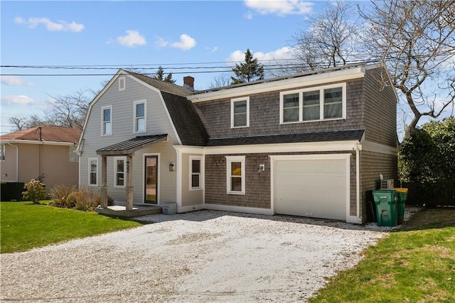 colonial inspired home with a gambrel roof, a chimney, driveway, a shingled roof, and a front yard