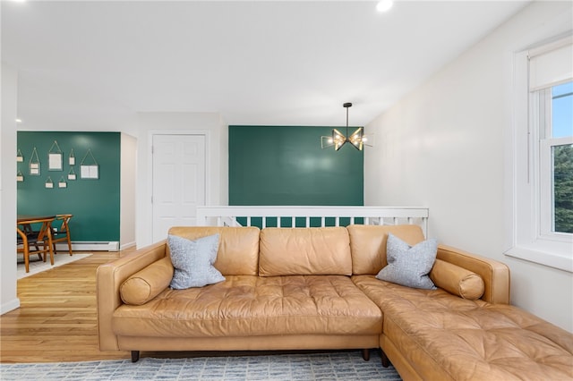 living area with baseboard heating, wood finished floors, an inviting chandelier, baseboards, and recessed lighting