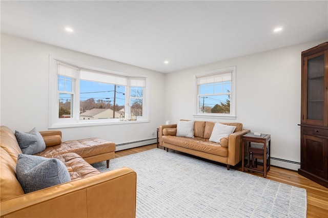 living area with plenty of natural light, wood finished floors, recessed lighting, and a baseboard radiator