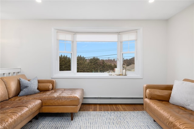 living room featuring a baseboard heating unit, a wealth of natural light, wood finished floors, and recessed lighting
