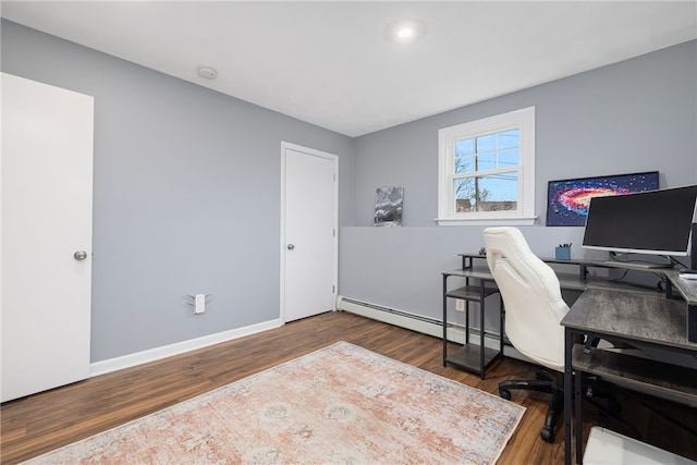office area featuring baseboard heating, baseboards, and wood finished floors