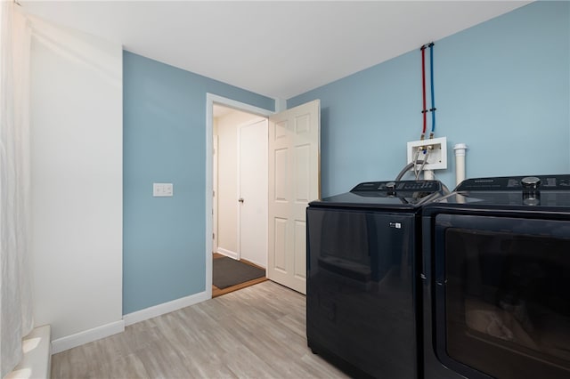 laundry room with light wood-style floors, baseboards, washer and dryer, and laundry area