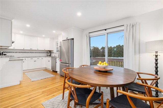 dining space with light wood-type flooring and recessed lighting