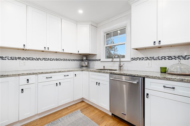 kitchen featuring a sink, tasteful backsplash, light wood-style floors, white cabinetry, and dishwasher