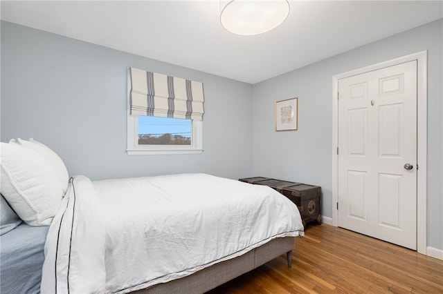 bedroom featuring wood finished floors and baseboards