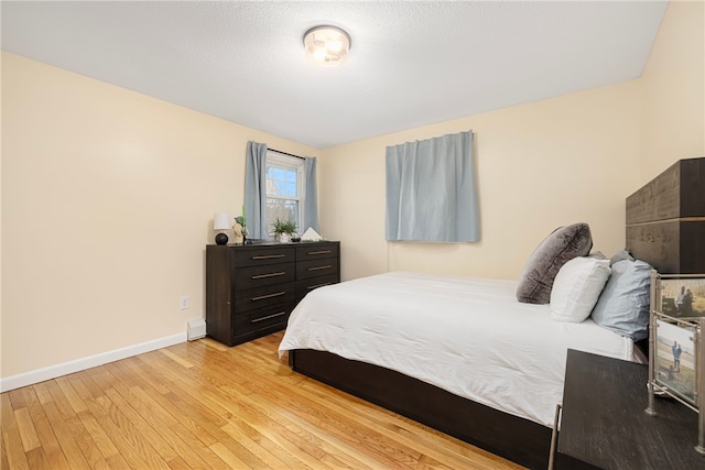 bedroom with light wood finished floors and baseboards