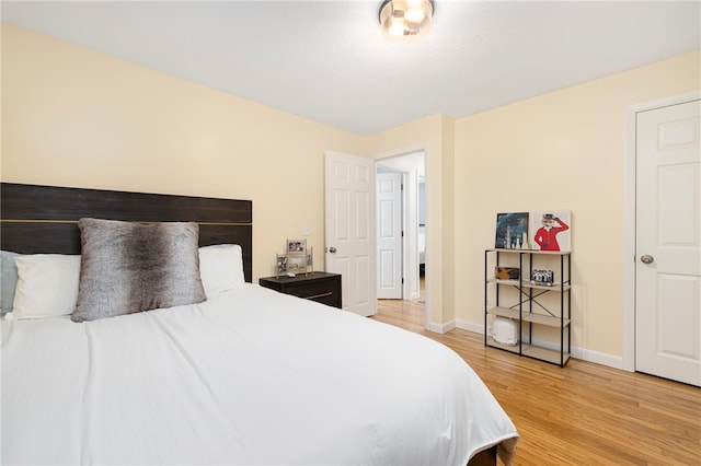 bedroom featuring baseboards and light wood-style flooring