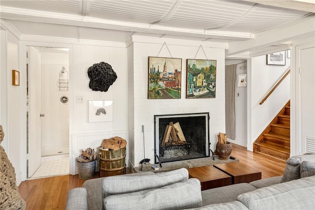 living area featuring wood finished floors, a fireplace, and stairway