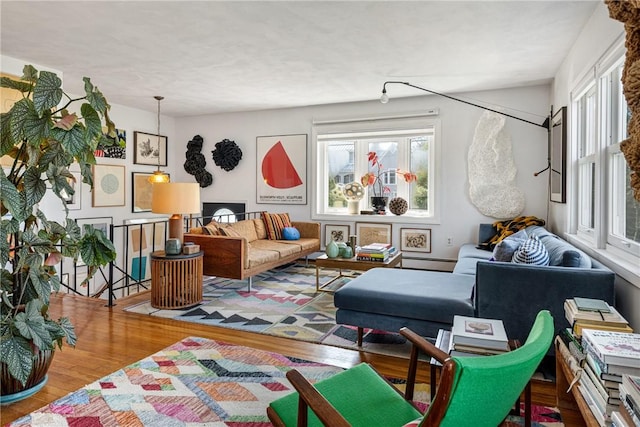 living area with a baseboard heating unit and wood finished floors