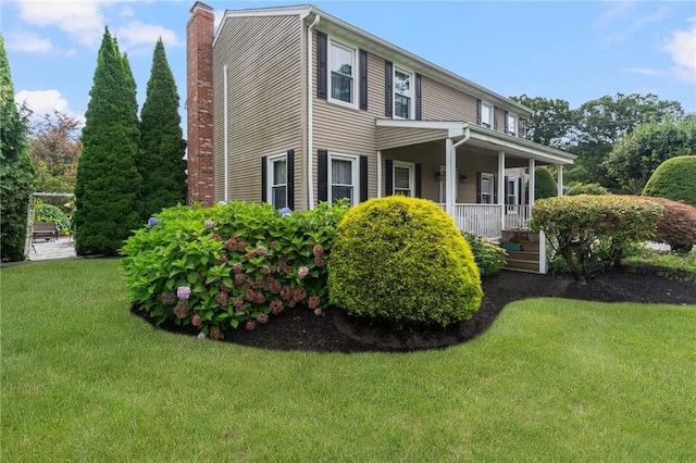 view of property exterior featuring a porch, a chimney, and a yard
