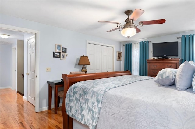 bedroom with ceiling fan, baseboards, a closet, and light wood-type flooring