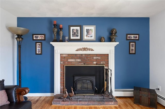 room details featuring a baseboard radiator, wood finished floors, and baseboards