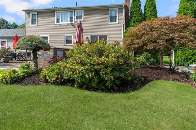 rear view of property with a yard and a patio