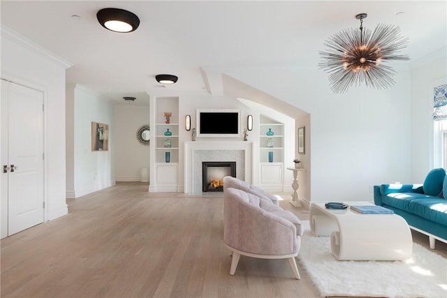 78 Rhode Island Ave Unit 8, Newport, RI 02840 - living area featuring a warm lit fireplace, a notable chandelier, built in features, light wood-type flooring, and crown molding