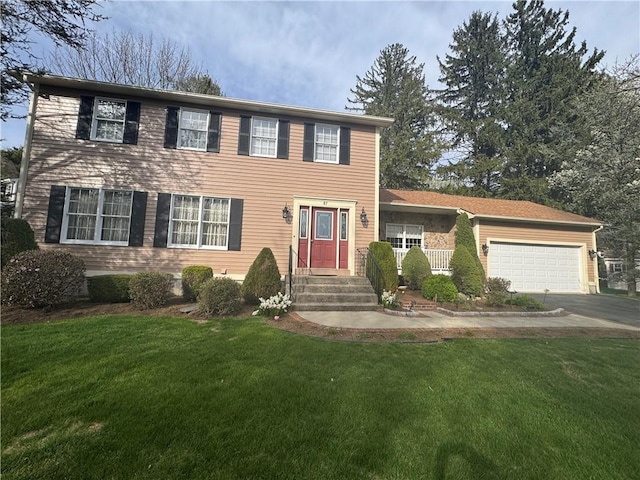 colonial home featuring an attached garage, aphalt driveway, and a front yard