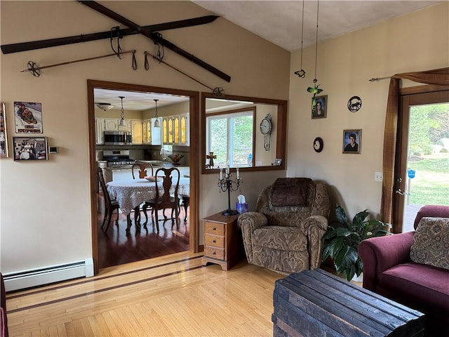 living room with a baseboard heating unit and light wood-style flooring