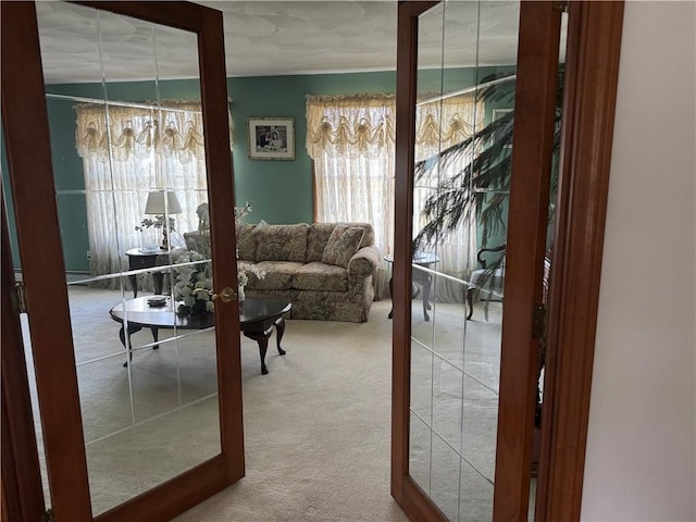 living room featuring a wealth of natural light, carpet flooring, and french doors