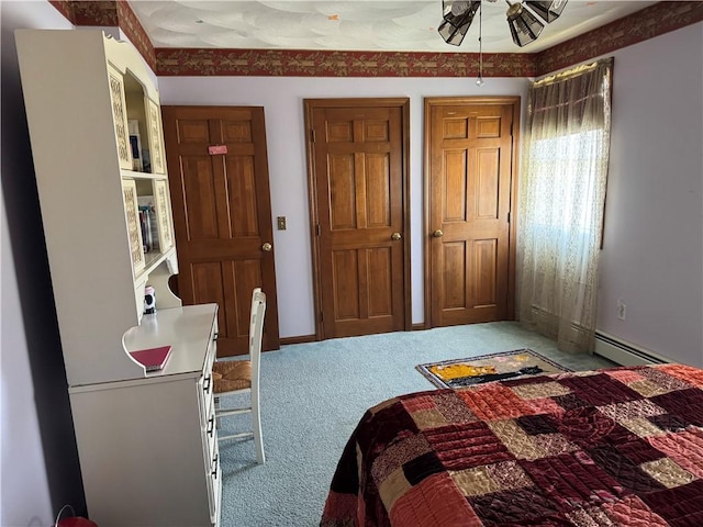 carpeted bedroom featuring a baseboard heating unit and baseboards