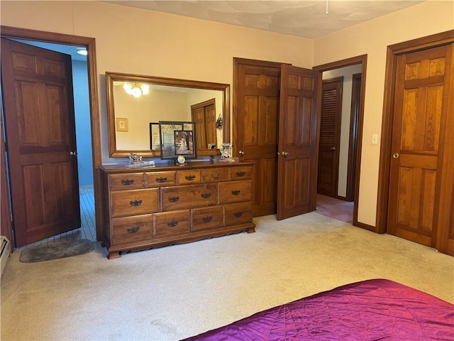 bedroom featuring light colored carpet and baseboards