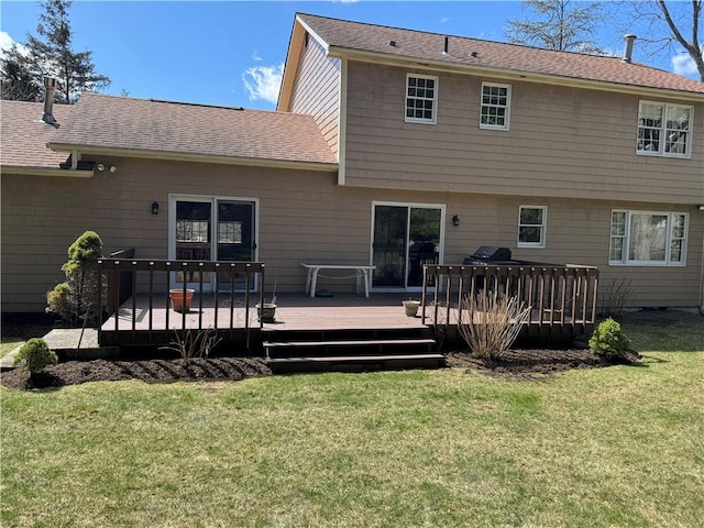 back of property with roof with shingles, a yard, and a deck