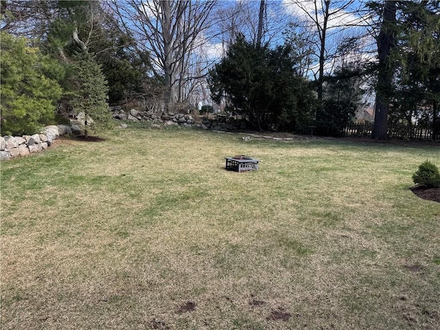 view of yard featuring fence and an outdoor fire pit
