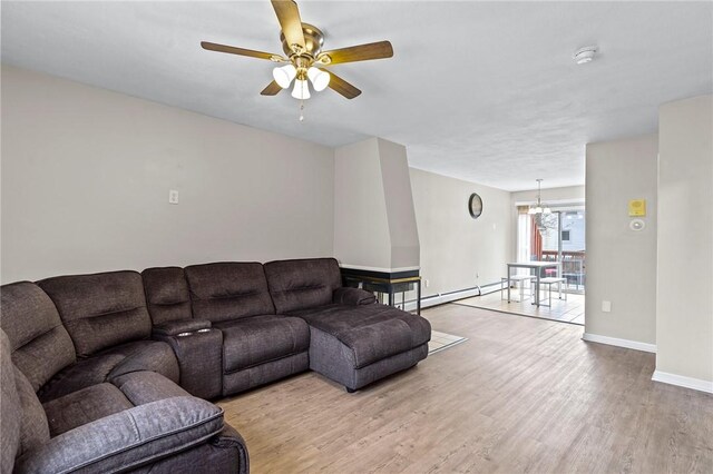 living room featuring wood finished floors, baseboards, ceiling fan, and baseboard heating