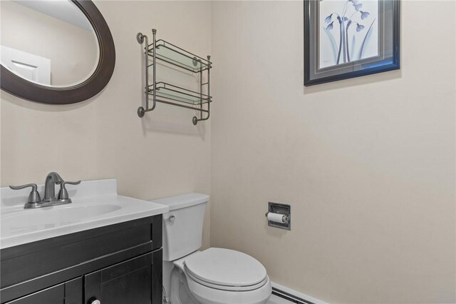 bathroom with toilet, vanity, and baseboards