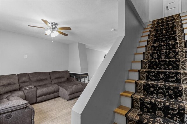 stairway with wood finished floors and ceiling fan