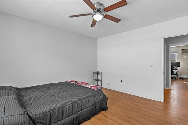 bedroom featuring baseboards, a ceiling fan, and light wood-style floors