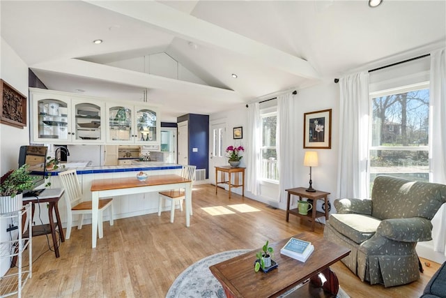 living area featuring recessed lighting, vaulted ceiling, light wood-type flooring, and a wealth of natural light
