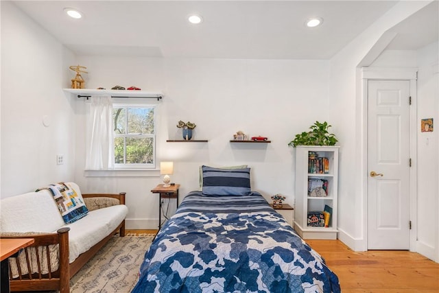 bedroom featuring baseboards, wood finished floors, and recessed lighting