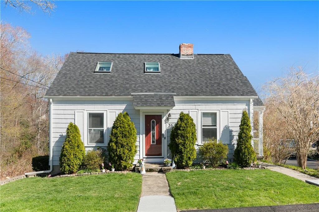 35 Sunset Ave, West Warwick, RI 02893 - new england style home with a chimney, a front lawn, and a shingled roof