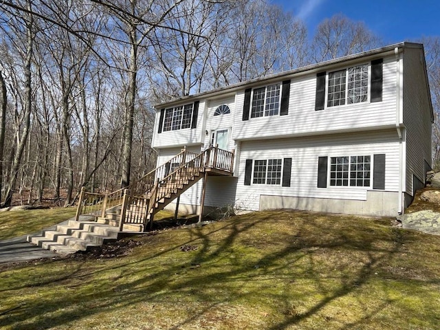 bi-level home featuring a front lawn and stairs