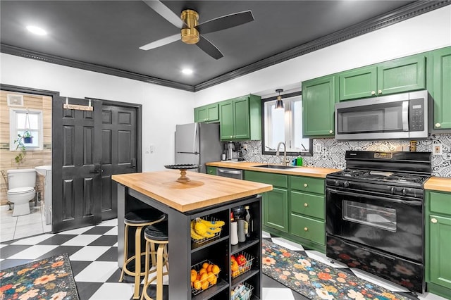134 Courtland St, Providence, RI 02909 - kitchen featuring butcher block counters, stainless steel appliances, a sink, green cabinets, and tile patterned floors