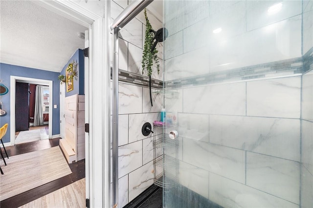 134 Courtland St, Providence, RI 02909 - bathroom featuring tiled shower, wood finished floors, a textured ceiling, and baseboards